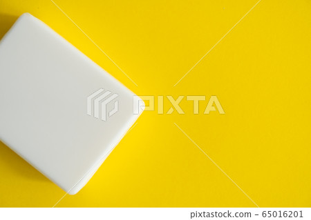White soap on a yellow background. Hand hygiene. Washing hands is a best way to prevent coronavirus Covid-19 while global pandemic. White soap on a yellow background. Hand hygiene. Washing hands is a best way to prevent coronavirus Covid-19 while global pandemic. 65016201