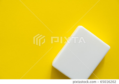 White soap on a yellow background. Hand hygiene. Washing hands is a best way to prevent coronavirus Covid-19 while global pandemic. White soap on a yellow background. Hand hygiene. Washing hands is a best way to prevent coronavirus Covid-19 while global pandemic. 65016202