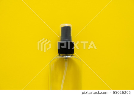 Bottle of antiseptic, a bottle of hand sanitizer, hand sanitizer spray on a yellow background, for the prevention of coronavirus. Bottle of antiseptic spray mockup, copy space for design. 65016205