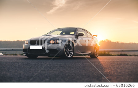 Silver metallic color sport car under the sunset 65016266