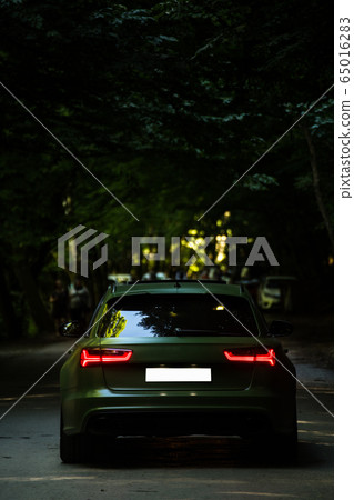 Grey offroader with red lights in a recreation zone across forest Grey offroader with red lights in a recreation zone across forest 65016283