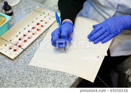 Doctor's hands fill in different tables and forms Doctor's hands fill in different tables and forms 65016316