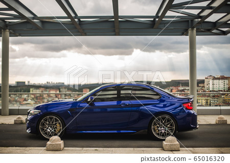 Parking blue sedan outdoor, in a modern parking lot Parking blue sedan outdoor, in a modern parking lot 65016320