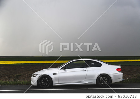 White luxury sedan on the highway in the fog 65016718