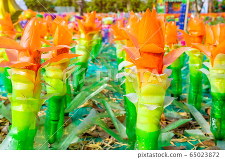 Recycled colorful plastic flowers made from plastic bottles to decorate as flowers in the garden. Plastic bottle recycled. 65023872