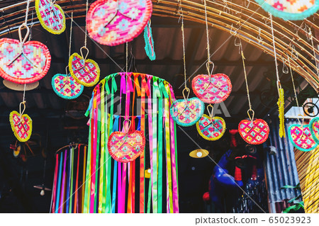 Many colorful of fanning woven from bamboo are hung above to decorate the walkway in the annual happiness festival in public park. Selective focus. Many colorful of fanning woven from bamboo are hung above to decorate the walkway in the annual happiness festival in public park. Selective focus. 65023923