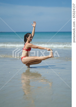 Asian Chinese Woman in various yoga poses at the Asian Chinese Woman in various yoga poses at the 65024137