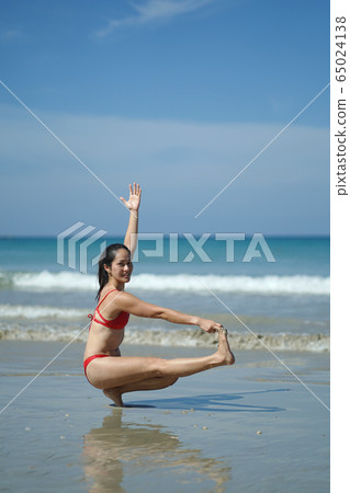Asian Chinese Woman in various yoga poses at the Asian Chinese Woman in various yoga poses at the 65024138