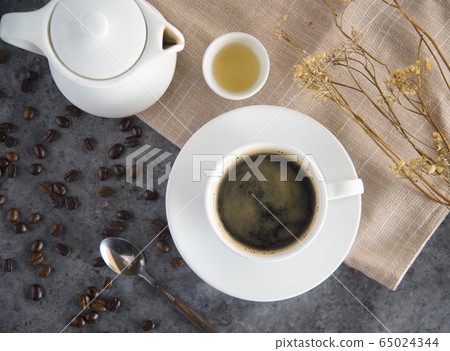 Coffee cup and coffee beans on table Coffee cup and coffee beans on table 65024344