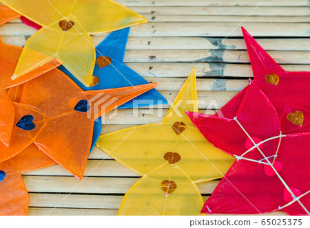 Close up to traditional star-shaped kite or thai name Chula kite for sale to fly at local market.  Selective focus. 65025375
