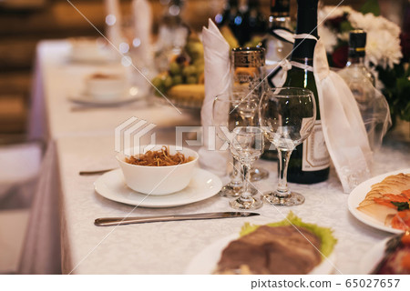 glasses and plates with snacks on the festive table 65027657