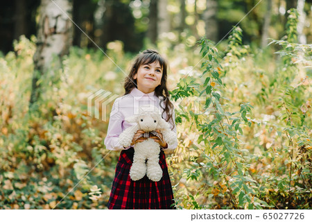 happy girl with soft toy in the Park 65027726