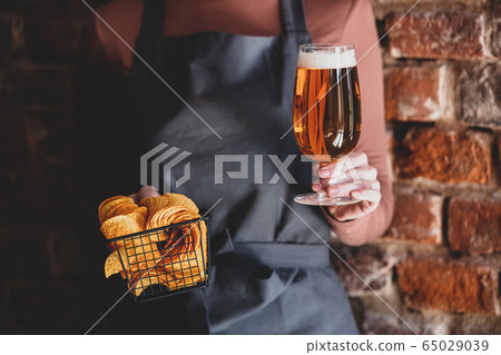 woman waiter holds beer and chips woman waiter holds beer and chips 65029039