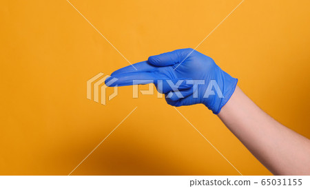 hand in a blue medical glove shows a gun epidemic coronavirus hand in a blue medical glove shows a gun epidemic coronavirus 65031155