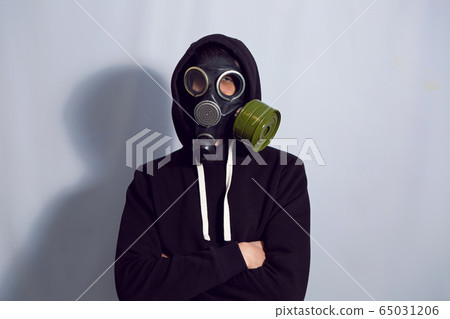 man in a black gas mask stands against a white wall man in a black gas mask stands against a white wall 65031206