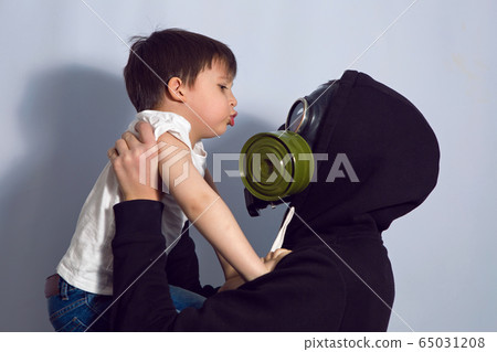 father and son stand in the apartment in a gas mask to protect father and son stand in the apartment in a gas mask to protect 65031208