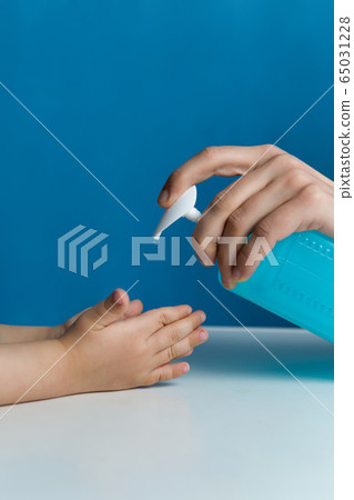 mom pours liquid soap on the palm of the child during the epidemic mom pours liquid soap on the palm of the child during the epidemic 65031228