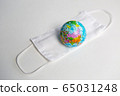 globe lies on a medical mask during a coronavirus 65031248