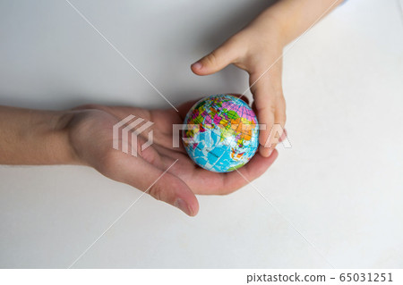 baby and hand of adult man holding a small globe during the epidemic baby and hand of adult man holding a small globe during the epidemic 65031251