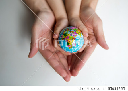 baby and hand of adult man holding a small globe during the epidemic 65031265