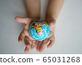 children's hands hold a small globe during a coronavirus 65031268