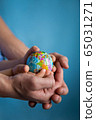 baby and hand of adult man holding a small globe during the epidemic 65031271