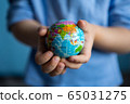 children's hands hold a small globe during a coronavirus 65031275