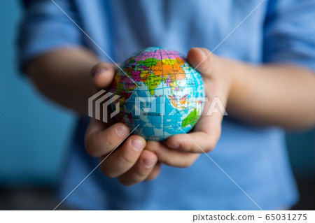 children's hands hold a small globe during a coronavirus 65031275