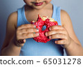 boy is holding two colored doughnuts blue and red in front 65031278