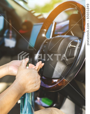 A woman wash her hands with blue alcohol gel to kill germs before driving car for hygiene purposes and prevents the spread of germs and avoids coronavirus (Covid-19) infection. Health care concept. A woman wash her hands with blue alcohol gel to kill germs before driving car for hygiene purposes and prevents the spread of germs and avoids coronavirus (Covid-19) infection. Health care concept. 65031849