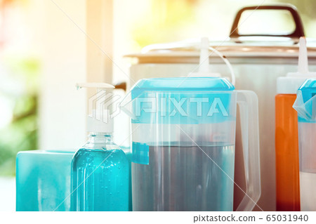 Blue alcohol gel bottle to prevent germs and the corona virus (Covid-19) before drinking water and eating in the student cafeteria. Blue alcohol gel bottle to prevent germs and the corona virus (Covid-19) before drinking water and eating in the student cafeteria. 65031940