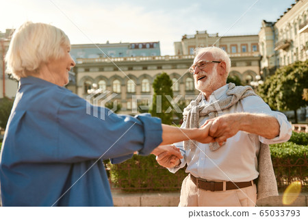 You are my soul! Beautiful senior couple smiling and dancing outdoors on a sunny day You are my soul! Beautiful senior couple smiling and dancing outdoors on a sunny day 65033793