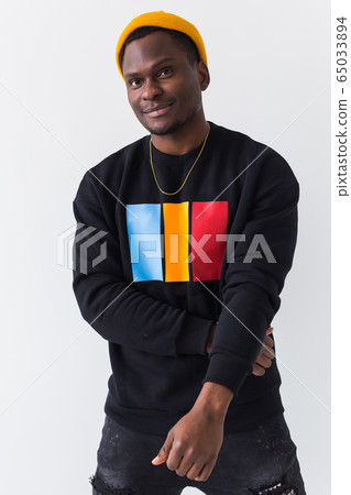 Portrait handsome young black man dressed in jeans and sweatshirt on white background. Street fashion and modern youth culture. Portrait handsome young black man dressed in jeans and sweatshirt on white background. Street fashion and modern youth culture. 65033894
