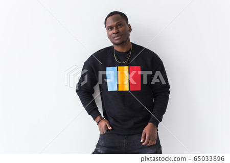 Handsome African American man posing in black sweatshirt on a white background. Youth street fashion photo with afro hairstyle. 65033896
