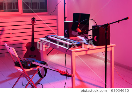 Microphone, computer and musical equipment guitars and piano background. Home recording studio concept. Microphone, computer and musical equipment guitars and piano background. Home recording studio concept. 65034650