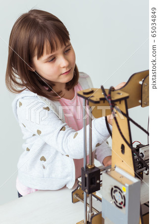 Child student makes the item on the 3D printer. School, technologies and science concept. Child student makes the item on the 3D printer. School, technologies and science concept. 65034849