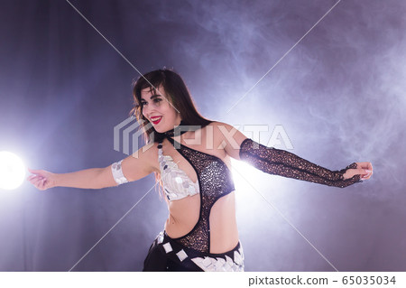 Spirituality dance. Beautiful sexy woman with luxury glossy eastern make-up dancing tribal fusion. Belly dance. 65035034