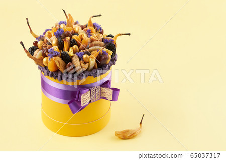 Yellow box with a bunch of dried fruits Yellow box with a bunch of dried fruits 65037317