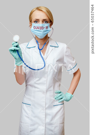 female doctor with stethoscope wearing protective mask and latex gloves over light grey background female doctor with stethoscope wearing protective mask and latex gloves over light grey background 65037464
