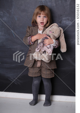 Cute Happy little girl hugging her toy rabbit 65038132