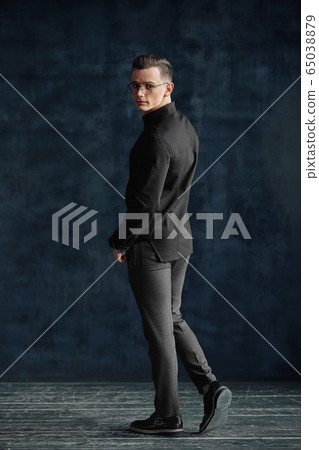 Modern young man in full growth. Confident young man posing for the camera in a loft studio. 65038879