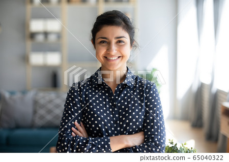 Confident smiling millennial indian woman standing with folded arms. Confident smiling millennial indian woman standing with folded arms. 65040322