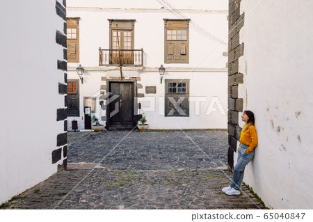Traveller young woman with the old architecture of city of Teguise in Lanzarote Traveller young woman with the old architecture of city of Teguise in Lanzarote 65040847
