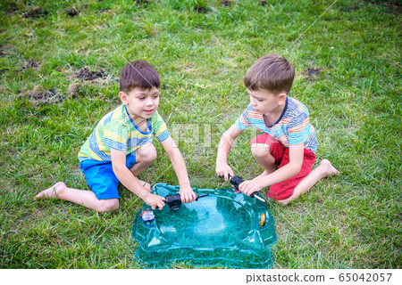 Two boys playing with a spinning top kid toy. Two boys playing with a spinning top kid toy. 65042057