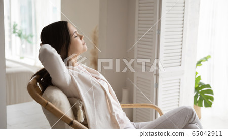 Calm girl relax in armchair taking nap Calm girl relax in armchair taking nap 65042911