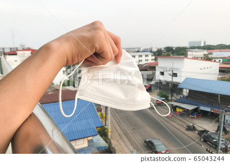 Hand holding disposable sanitation mask.Protect Hand holding disposable sanitation mask.Protect 65043244