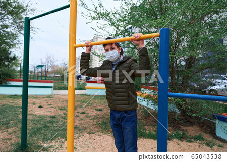 teen boy stands near horizontal bar of outdoor teen boy stands near horizontal bar of outdoor 65043538