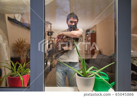 Man with cat stay at home, selfisolation to prevent spread infection. 65045866
