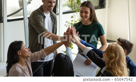 Multiracial workers with female leader, coach giving high five. 65047542