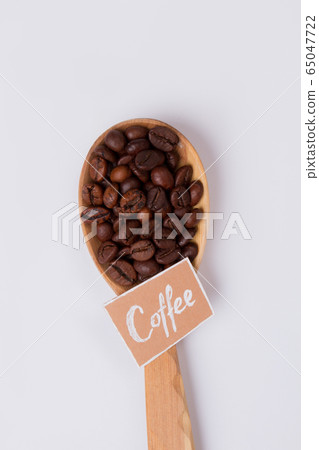 Roasted coffee beans in wooden spoon. Roasted coffee beans in wooden spoon. 65047722